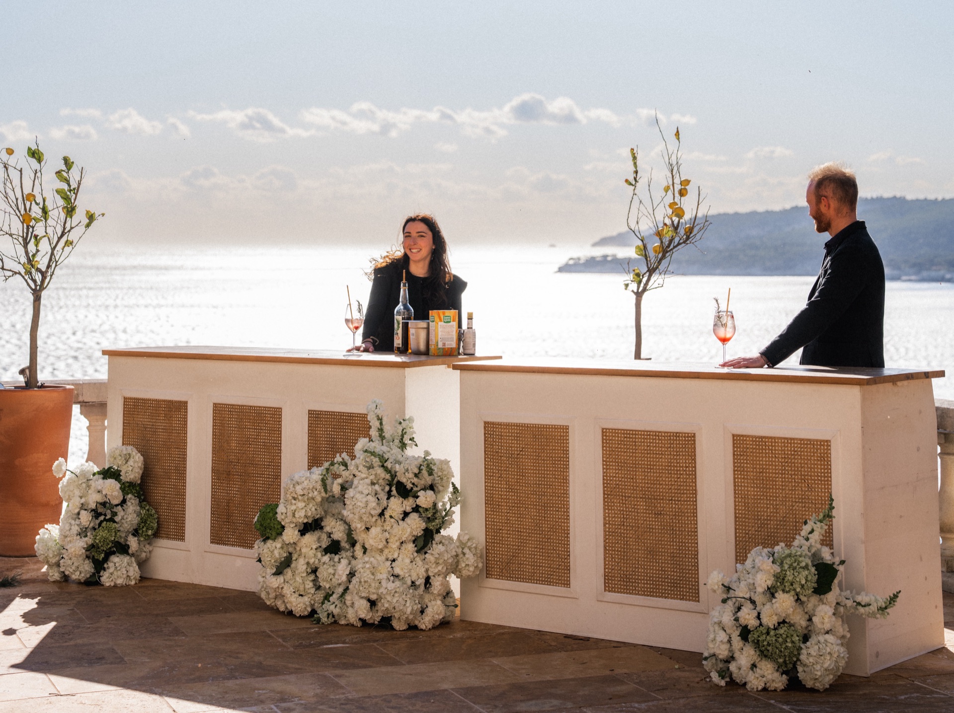 Bar mobile FMR décoré de fleurs blanches face à la mer pour un mariage